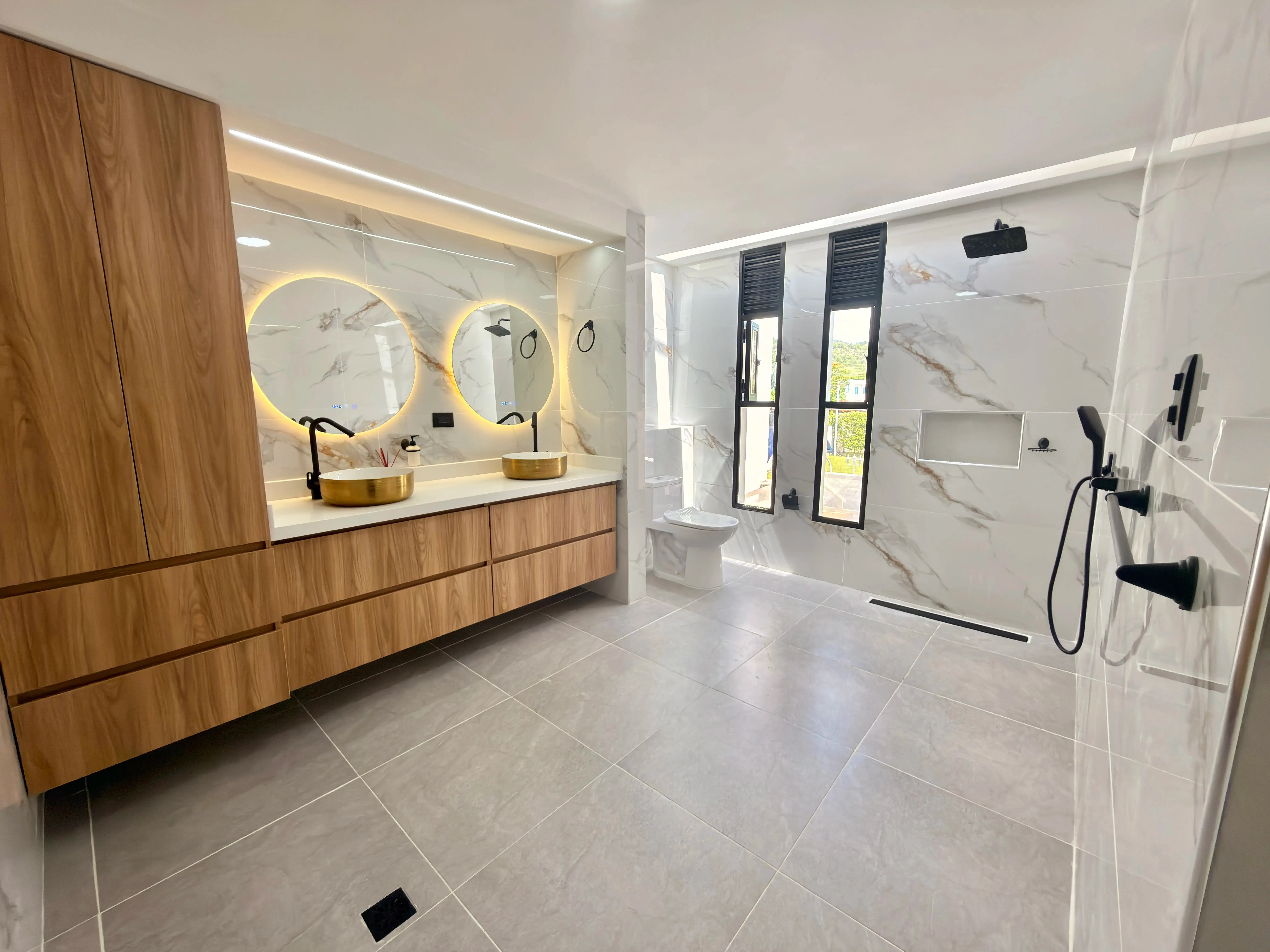 Baño remodelado con enchape de gran formato, ducha y acabados modernos — proyecto de JMP Diseños y Acabados en Melgar